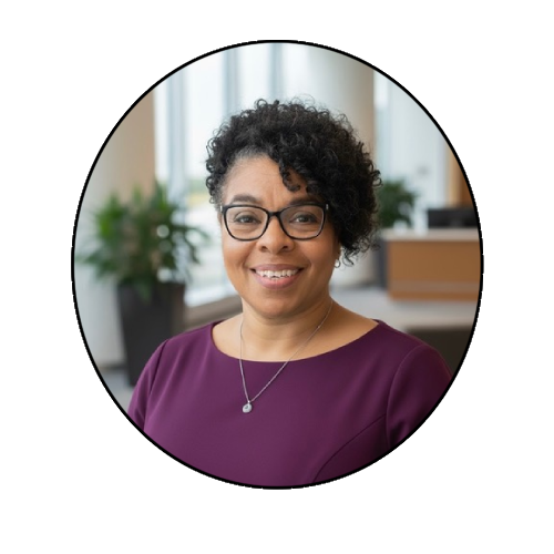 Smiling person in office setting, glasses worn.